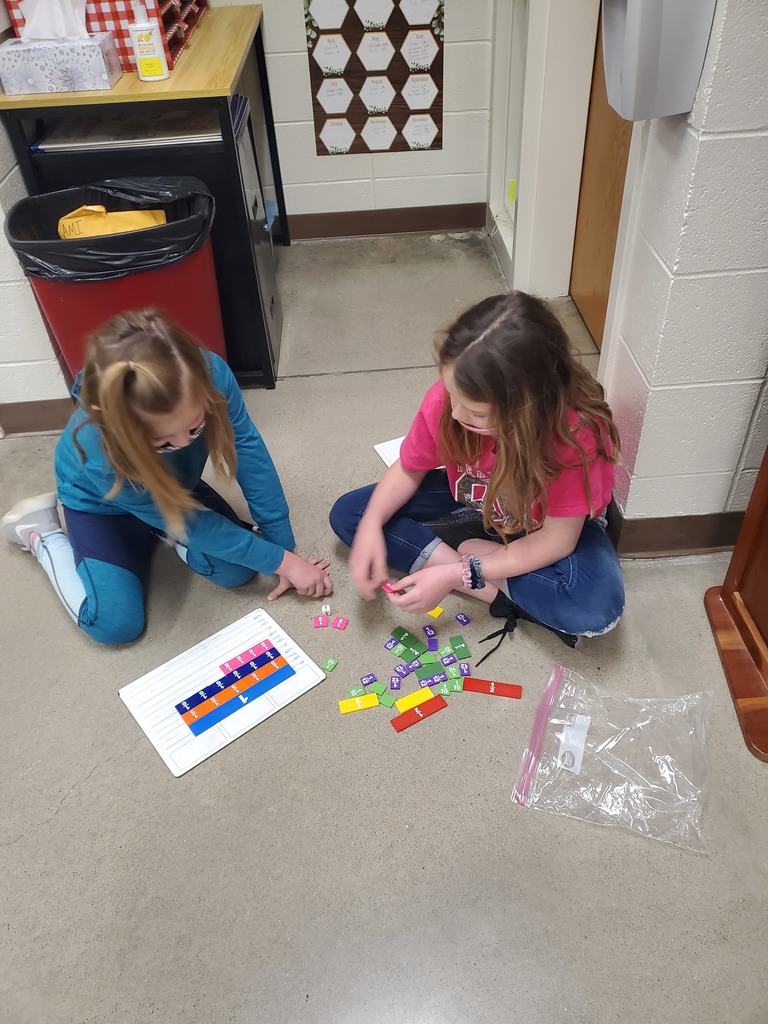 3rd-grade students are using fraction tiles to build equivalent fractions.