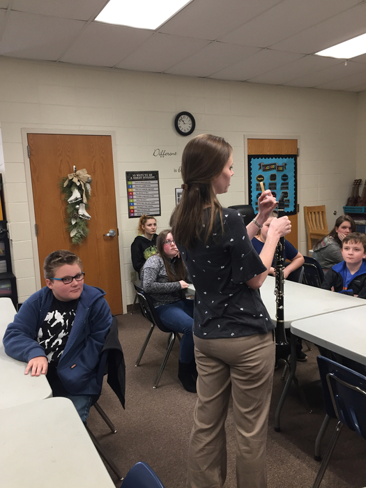 Ms. Love and band students demonstrating instruments in 6th grade music. 